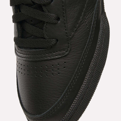 Close-up of the toe area of Reebok Club C 85 Shoes, featuring black leather, black laces, a textured rubber sole, visible stitching details, and small perforations on the upper.