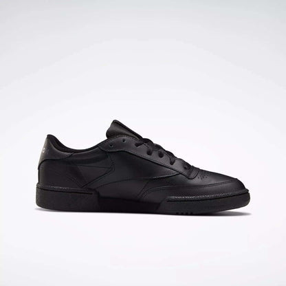The Reebok Club C 85 Shoes are black low-top leather sneakers with black laces and a textured rubber sole, inspired by the classic design, shown on a plain white background.