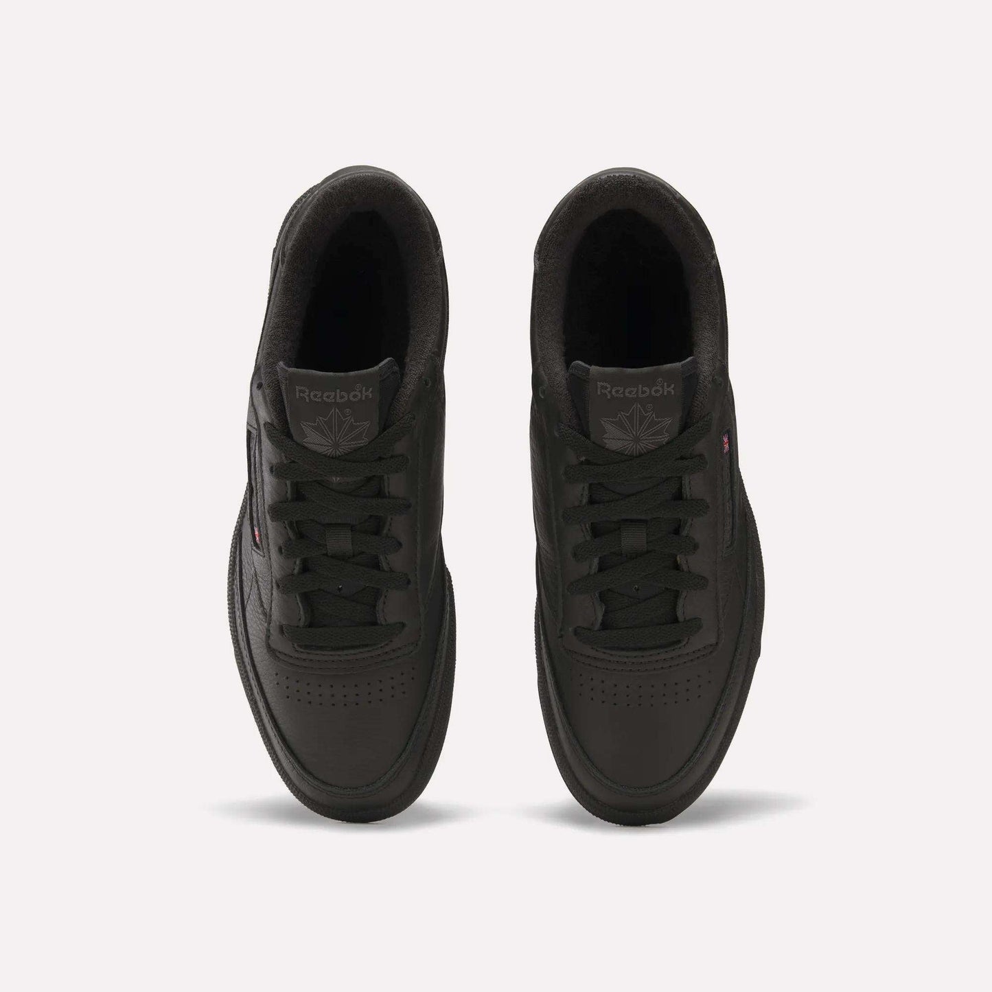 Top view of a pair of black Reebok Club C 85 Shoes with black laces, showing the Reebok logo on the tongue and a subtle side logo, placed on a plain white background.