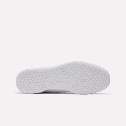 The image shows the bottom view of a white Reebok Club C 85 Shoes sole, with herringbone tread patterns and the Reebok logo embossed at the center.