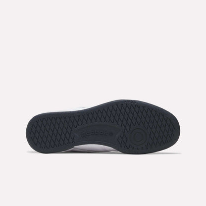 The image displays the black rubber sole of Reebok Club C 85 Shoes from the bottom, highlighting a diamond-shaped tread, circular accents, and the embossed Reebok logo in the center.