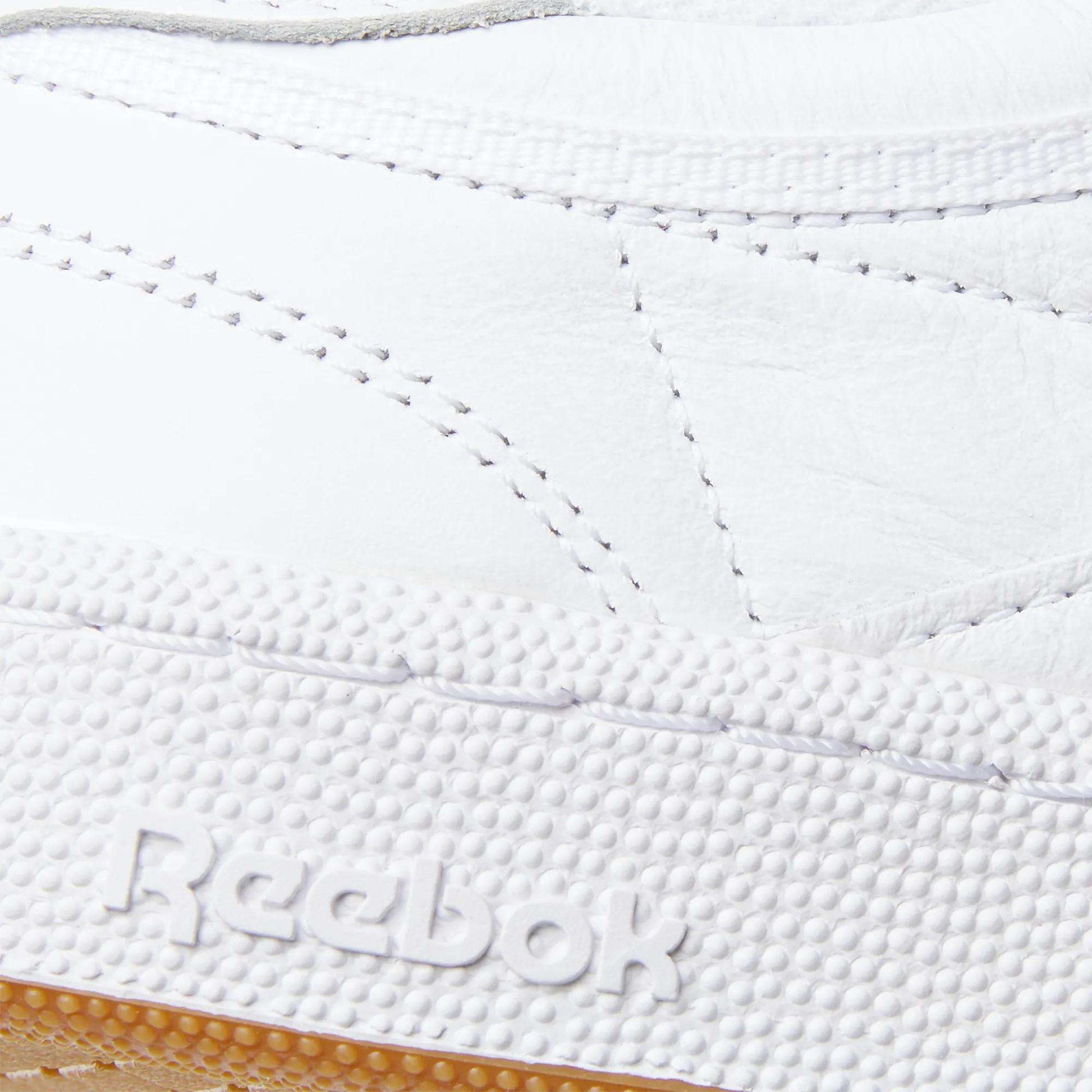 Close-up of the Reebok Club C 85 Shoes, showcasing detailed stitching on the white leather upper and the embossed Reebok logo on the textured rubber sole.