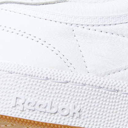 Close-up of the Reebok Club C 85 Shoes, showcasing detailed stitching on the white leather upper and the embossed Reebok logo on the textured rubber sole.