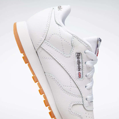 The Reebok Kids' Classic Leather Shoes - Preschool feature a white leather upper, gum sole, visible side logo, and white laces, shown on a white background.
