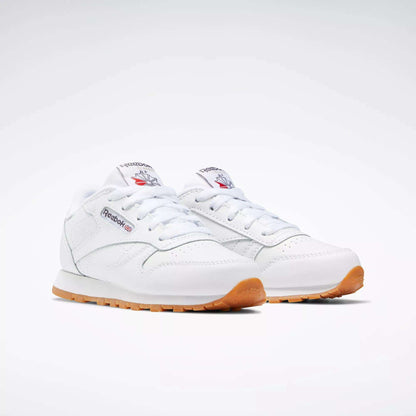 Kids' Classic Leather Shoes - Preschool by Reebok: white leather upper, gum soles, white laces, and signature Reebok logo with red and blue accents on the side and tongue. Displayed on a plain light background.
