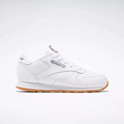 The Reebok Kids' Classic Leather Shoes - Preschool are shown in profile with a white leather upper, gum sole, white laces, stitching details, and the Reebok logo with a Union Jack flag on the side against a plain light background.