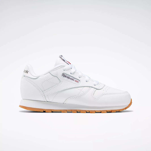 The Reebok Kids' Classic Leather Shoes - Preschool are shown in profile with a white leather upper, gum sole, white laces, stitching details, and the Reebok logo with a Union Jack flag on the side against a plain light background.