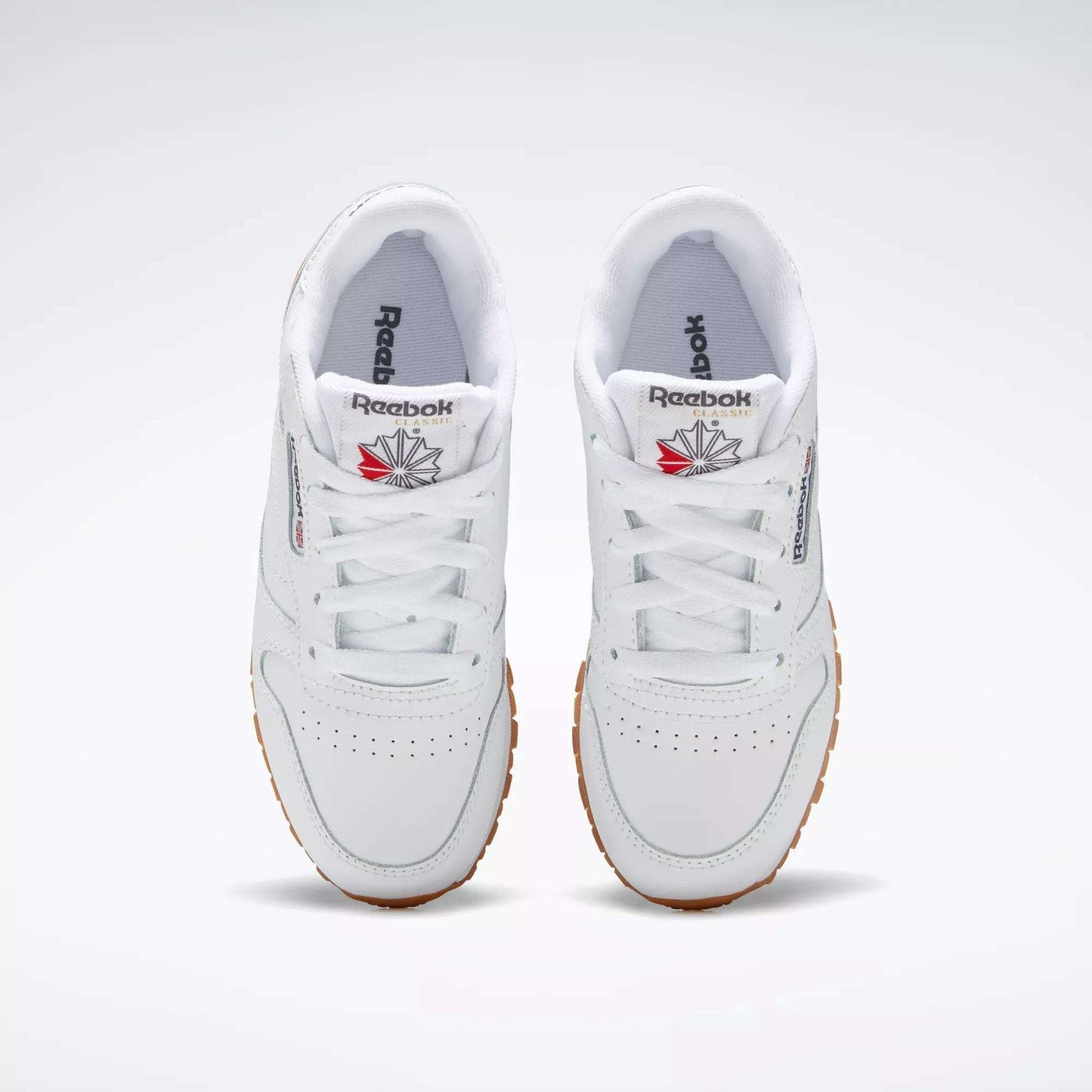 The Reebok Kids' Classic Leather Shoes - Preschool feature a white leather upper and lightweight cushioning, offering all-day comfort for kids.