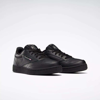 A pair of Reebok Kids' Club C Shoes - Grade School with black leather uppers, black soles and laces, the Reebok logo and a small Union Jack on the side, displayed on a plain white background.
