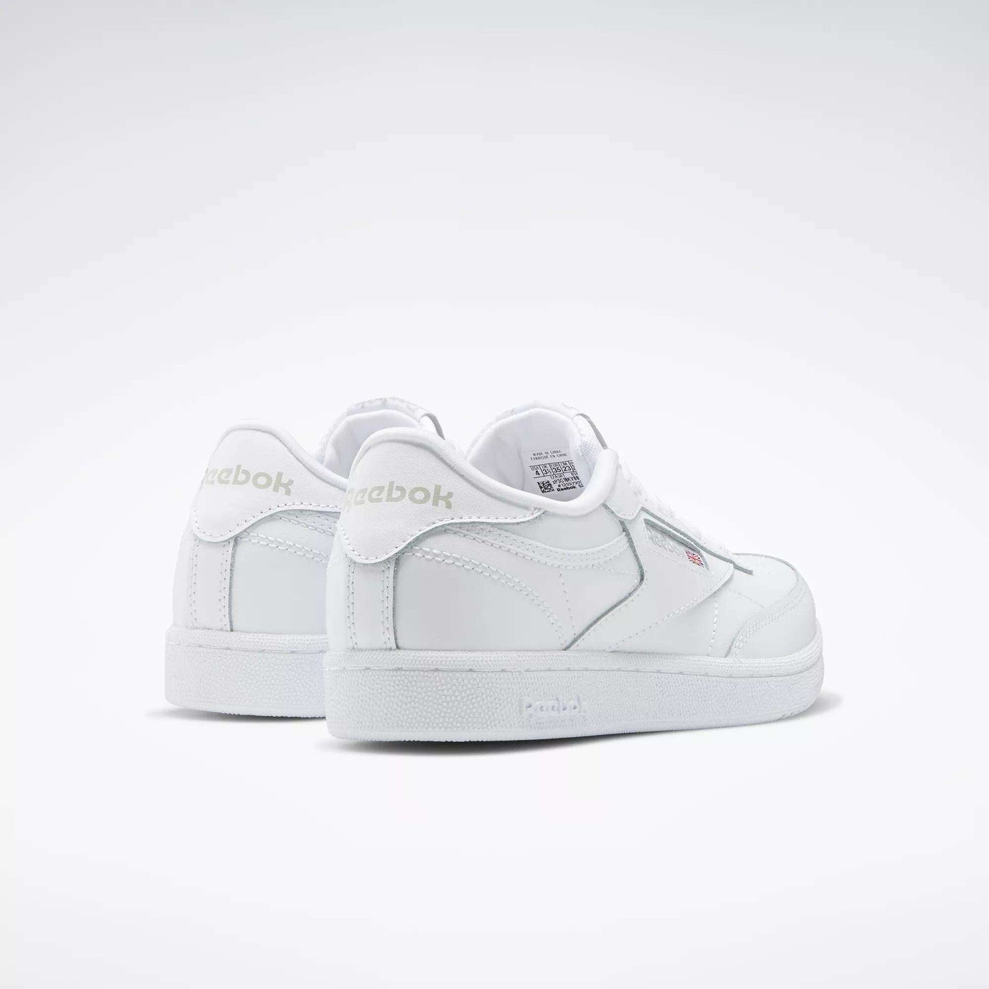 A pair of Reebok Kids' Club C Shoes - Grade School is displayed on a plain white background, featuring soft leather uppers, a low-cut silhouette, subtle stitching details, and visible Reebok branding on the side and heel.