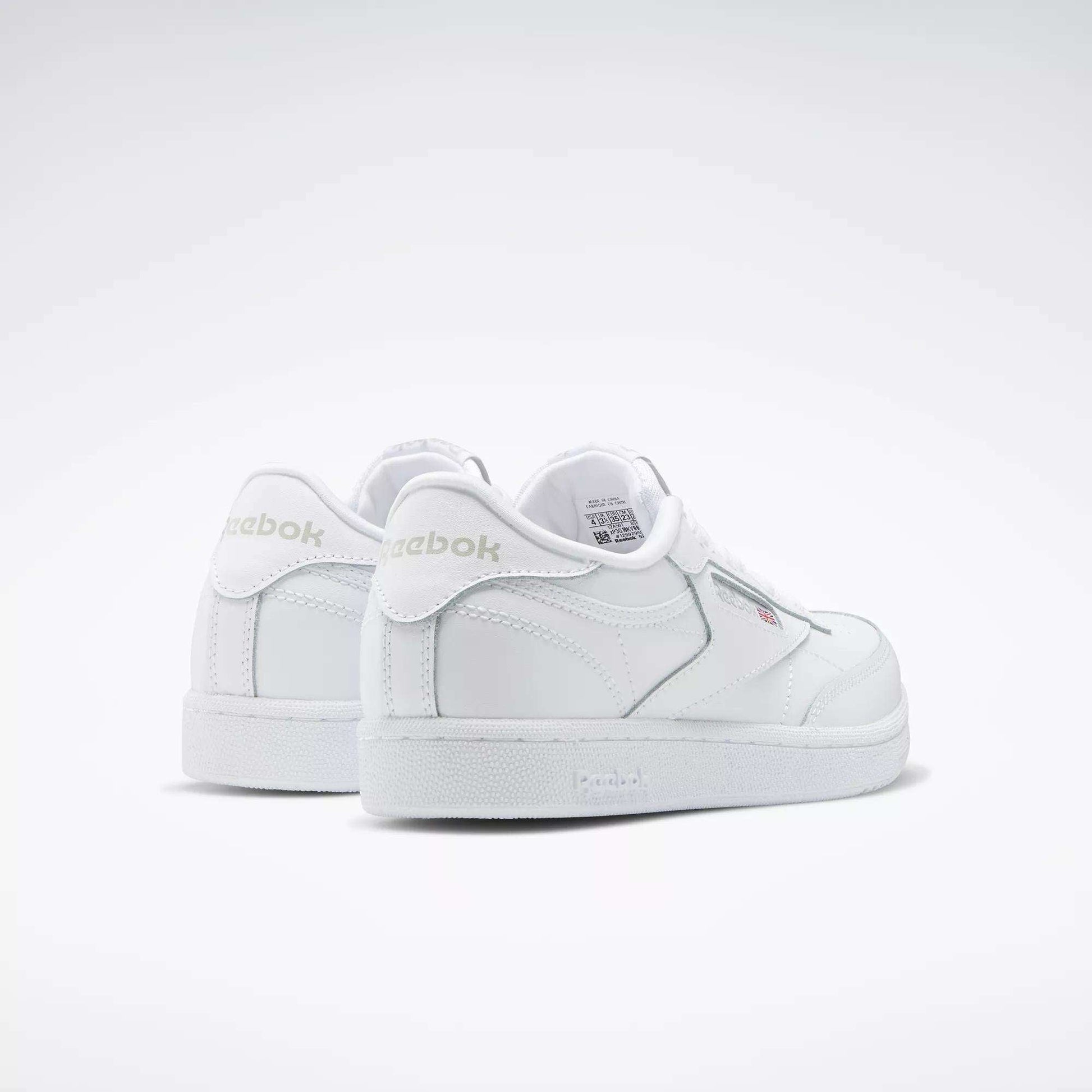 A pair of Reebok Kids' Club C Shoes - Grade School is displayed on a plain white background, featuring soft leather uppers, a low-cut silhouette, subtle stitching details, and visible Reebok branding on the side and heel.