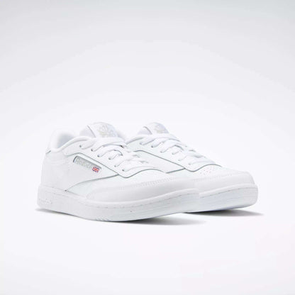 A pair of Reebok Kids' Club C Shoes for grade school, featuring classic low-top style, soft leather uppers, the Reebok logo, and a small Union Jack flag on the side, shown on a white background.