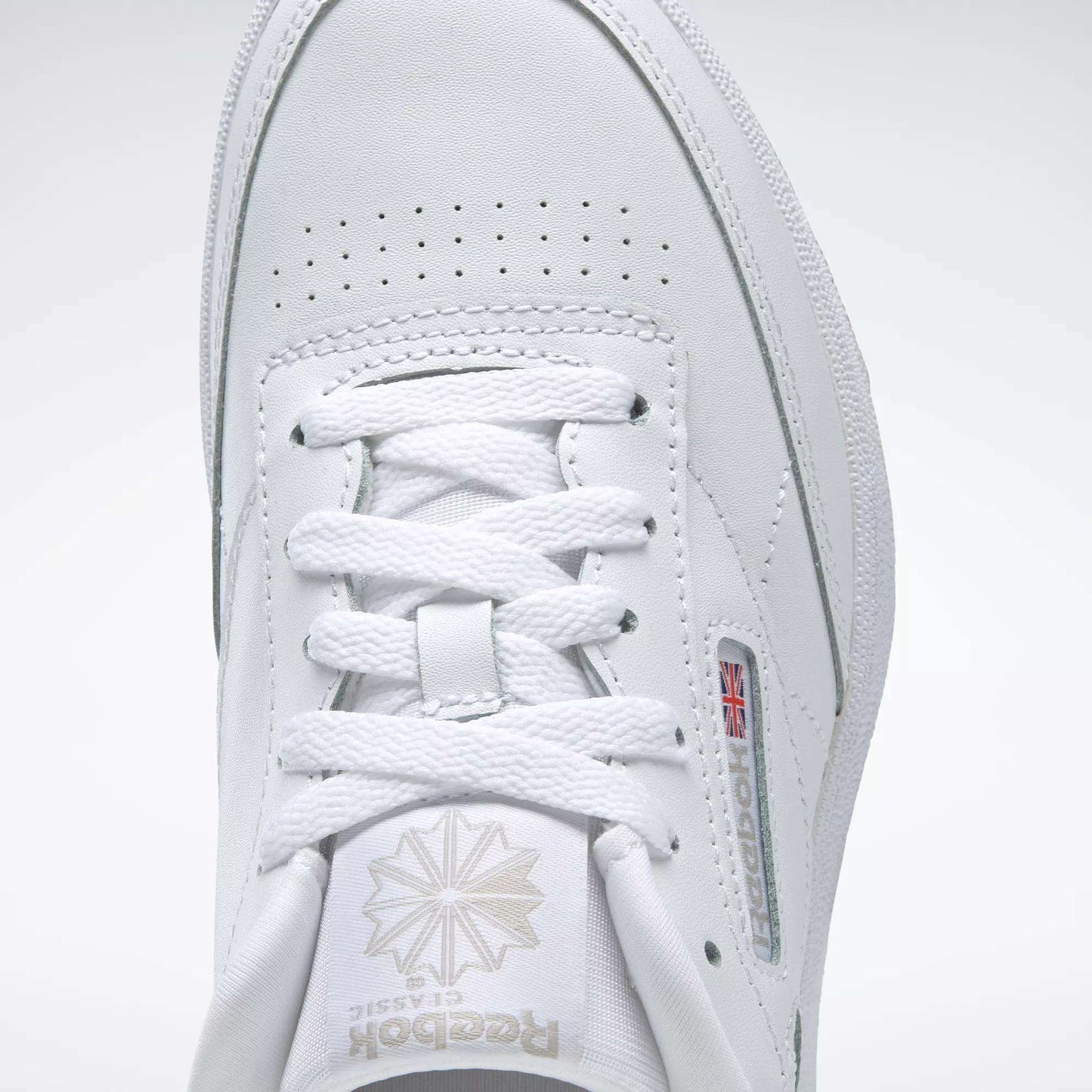 Close-up of the Reebok Kids' Club C Shoes - Grade School, showcasing the top view with laces, Reebok logo with Union Jack side detail, and soft leather uppers for timeless comfort.