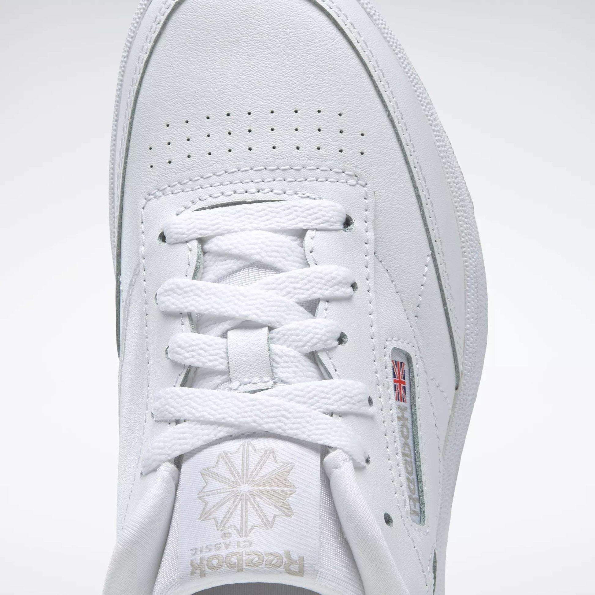 Close-up of the Reebok Kids' Club C Shoes - Grade School, showcasing the top view with laces, Reebok logo with Union Jack side detail, and soft leather uppers for timeless comfort.