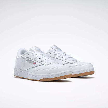 The Reebok Kids' Club C Shoes - Grade School feature classic white soft leather uppers, gum soles, and display the Reebok logo with a British flag on the side, shown against a plain white background.