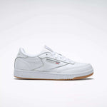 The Reebok Kids' Club C Shoes - Grade School feature soft white leather uppers, a gum sole, side branding, and perforated accents, displayed on a plain light gray background.