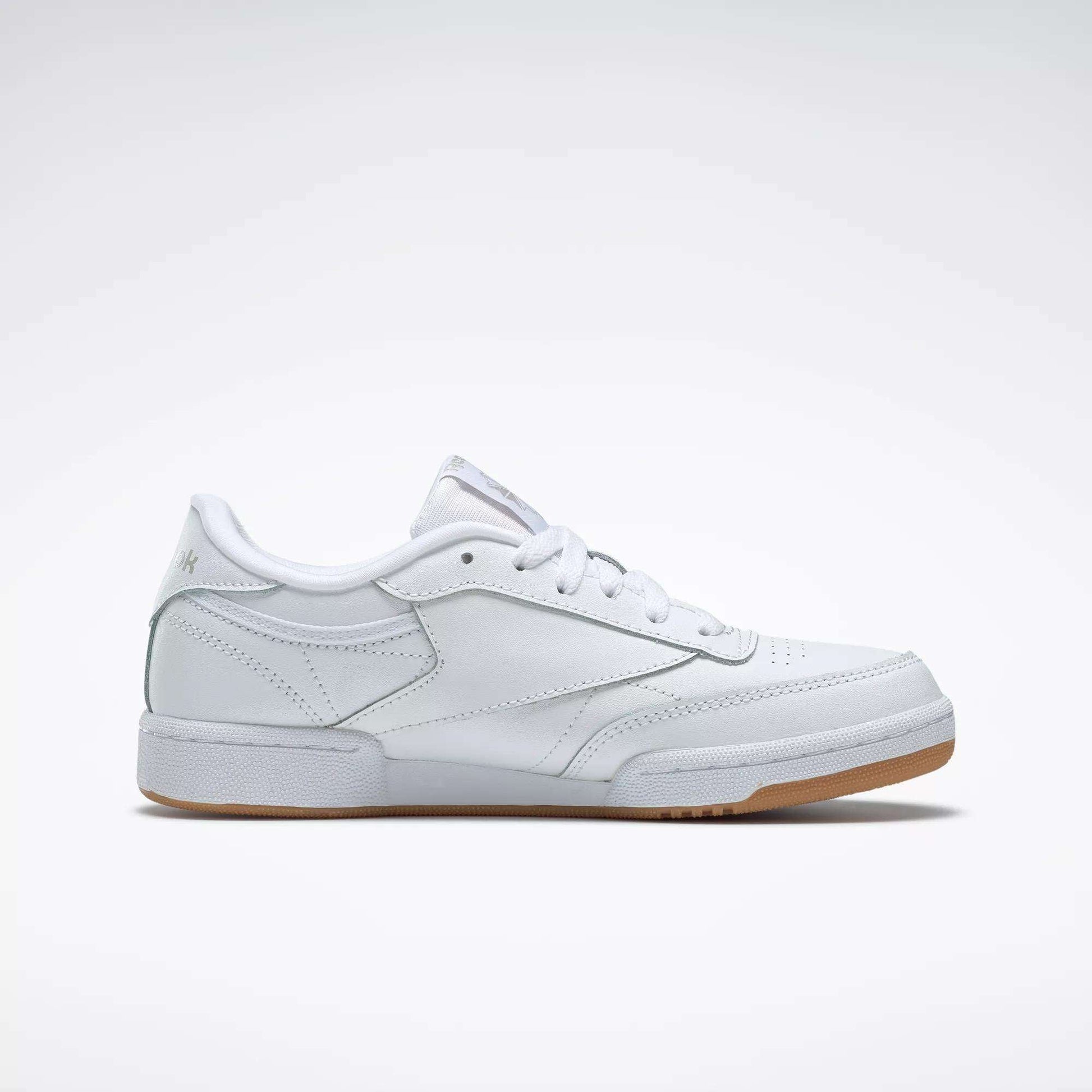 The Reebok Kids' Club C Shoes - Grade School feature soft white leather uppers, white laces, subtle stitching, and a light tan rubber sole, shown against a plain white background.