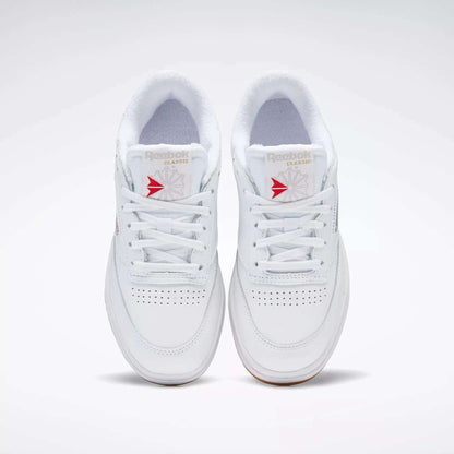 A pair of white Reebok Women's Club C Double Shoes with white laces, seen from above, featuring perforated toe details, a platform midsole, and Reebok branding on the tongue.