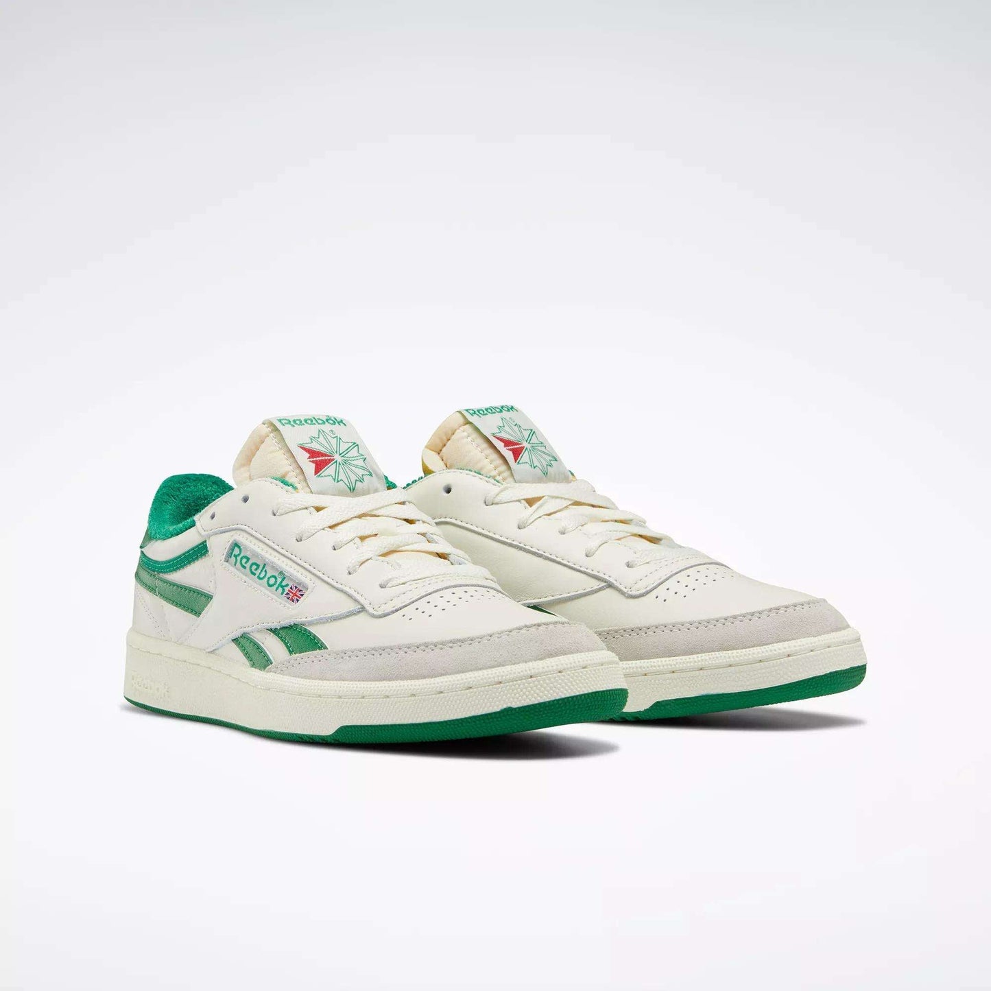 The Men's Club C Revenge Vintage Shoes by Reebok feature off-white leather, green accents and soles, plus classic branding for a retro tennis-inspired look, shown against a white background.