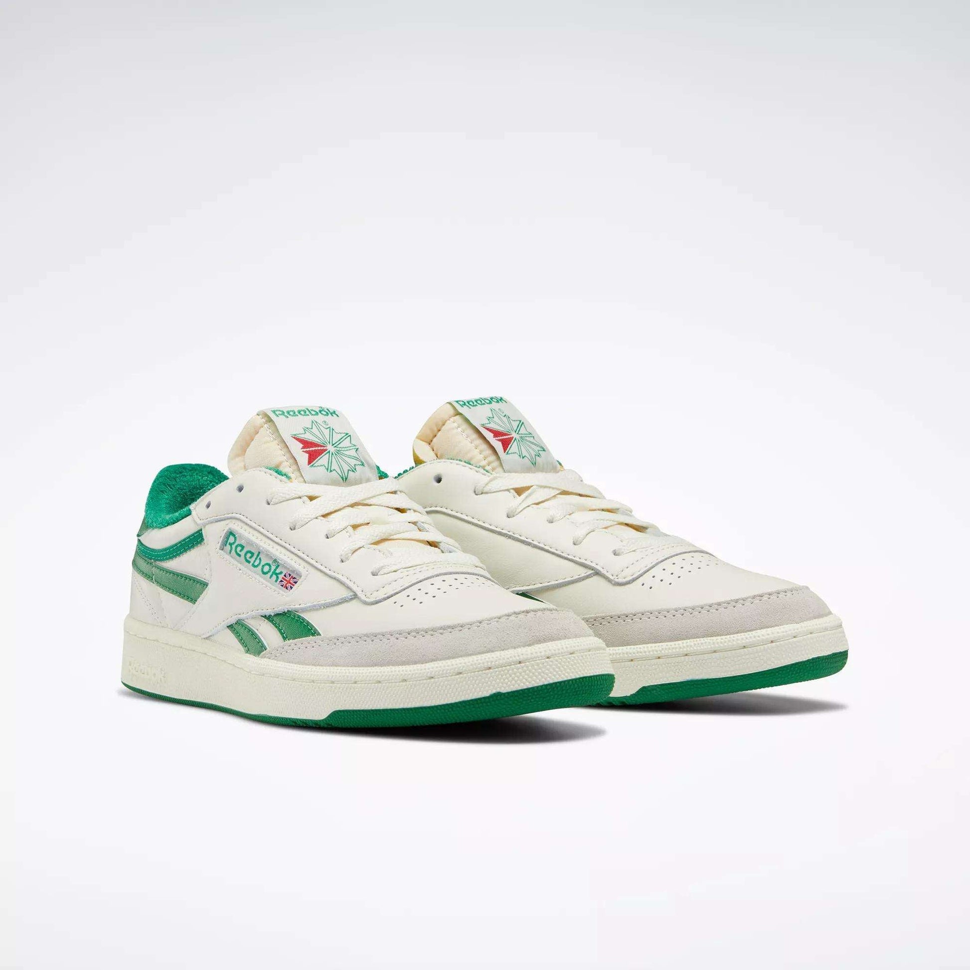 The Men's Club C Revenge Vintage Shoes by Reebok feature off-white leather, green accents and soles, plus classic branding for a retro tennis-inspired look, shown against a white background.