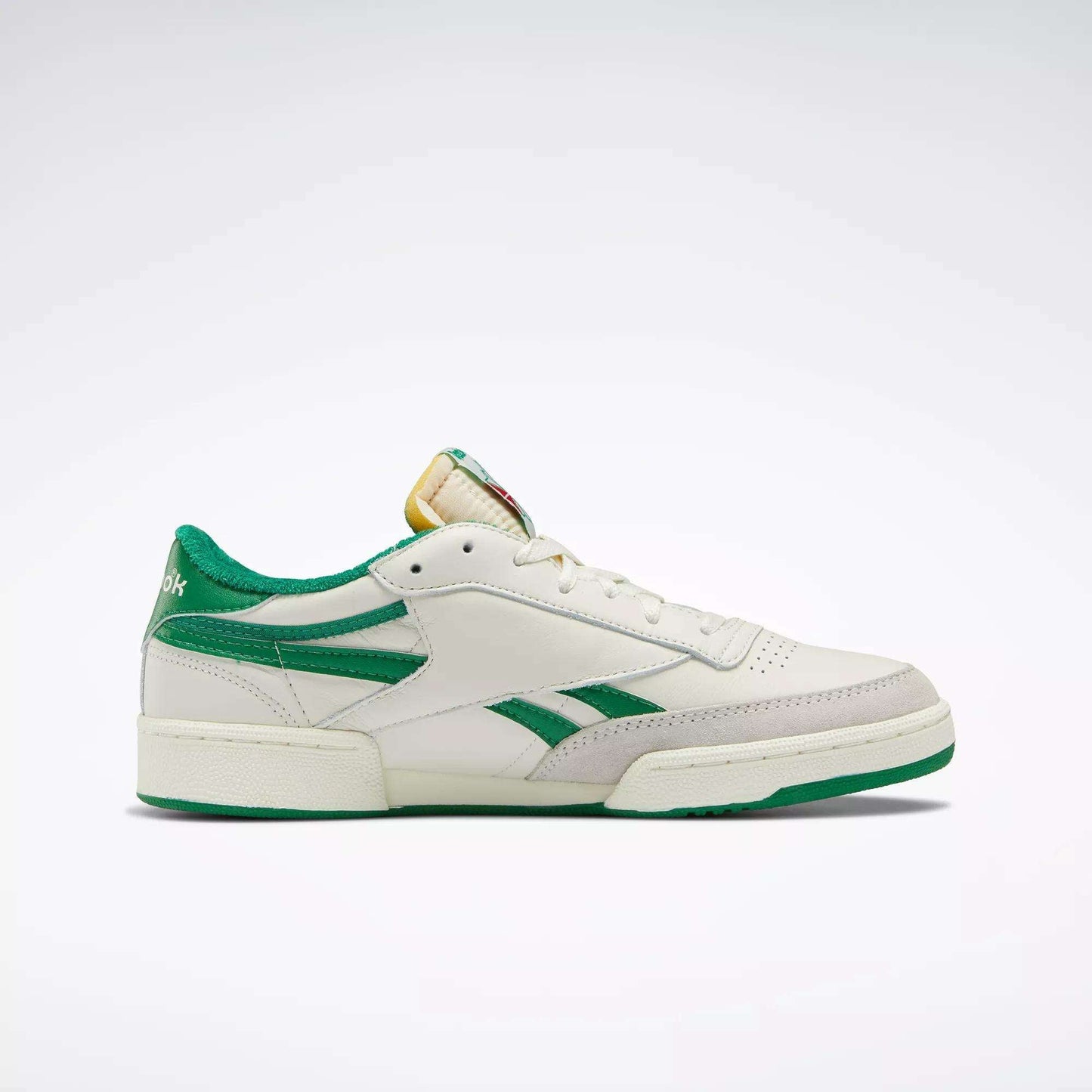 The Reebok Men's Club C Revenge Vintage Shoes are white leather sneakers with green accents, a green heel and sole, and a yellow tongue detail, displayed in profile on a plain light background.