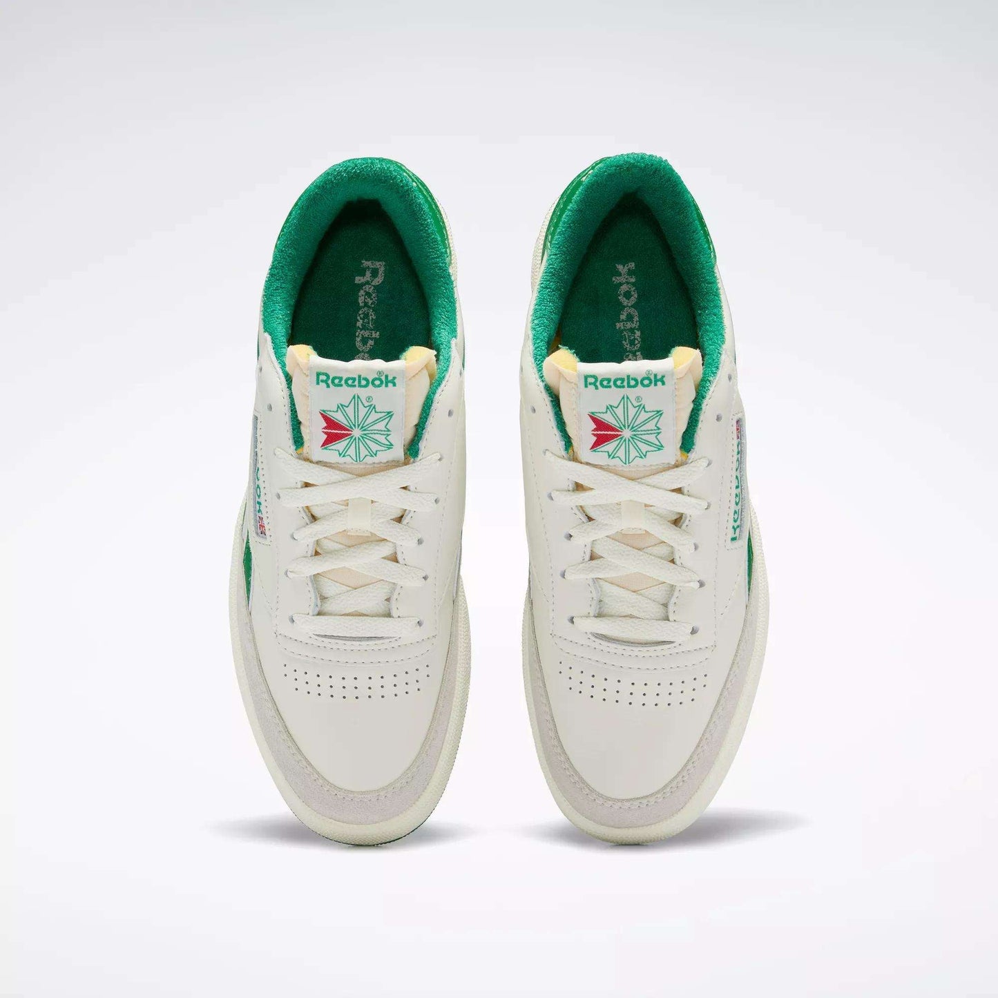 A top view of the Men's Club C Revenge Vintage Shoes by Reebok, white with green interiors and accents. These tennis-inspired sneakers feature the Reebok logo, tongue detailing, and perforated toes for retro style.