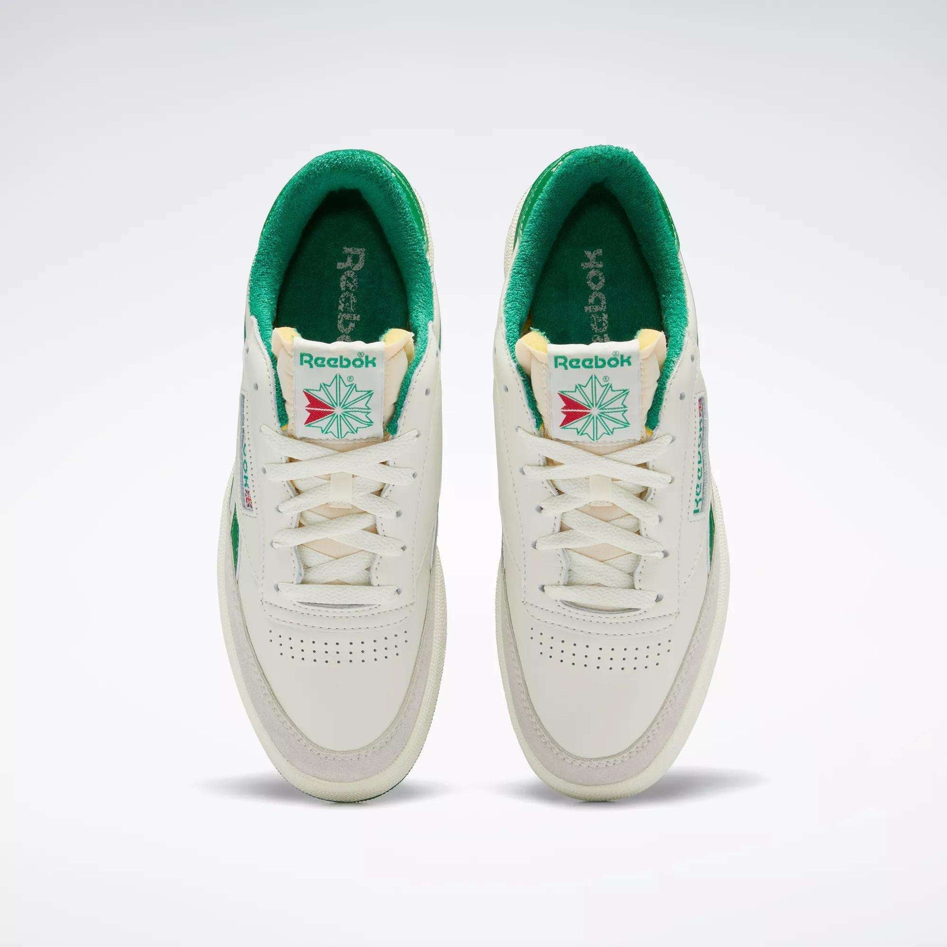 A top view of the Men's Club C Revenge Vintage Shoes by Reebok, white with green interiors and accents. These tennis-inspired sneakers feature the Reebok logo, tongue detailing, and perforated toes for retro style.