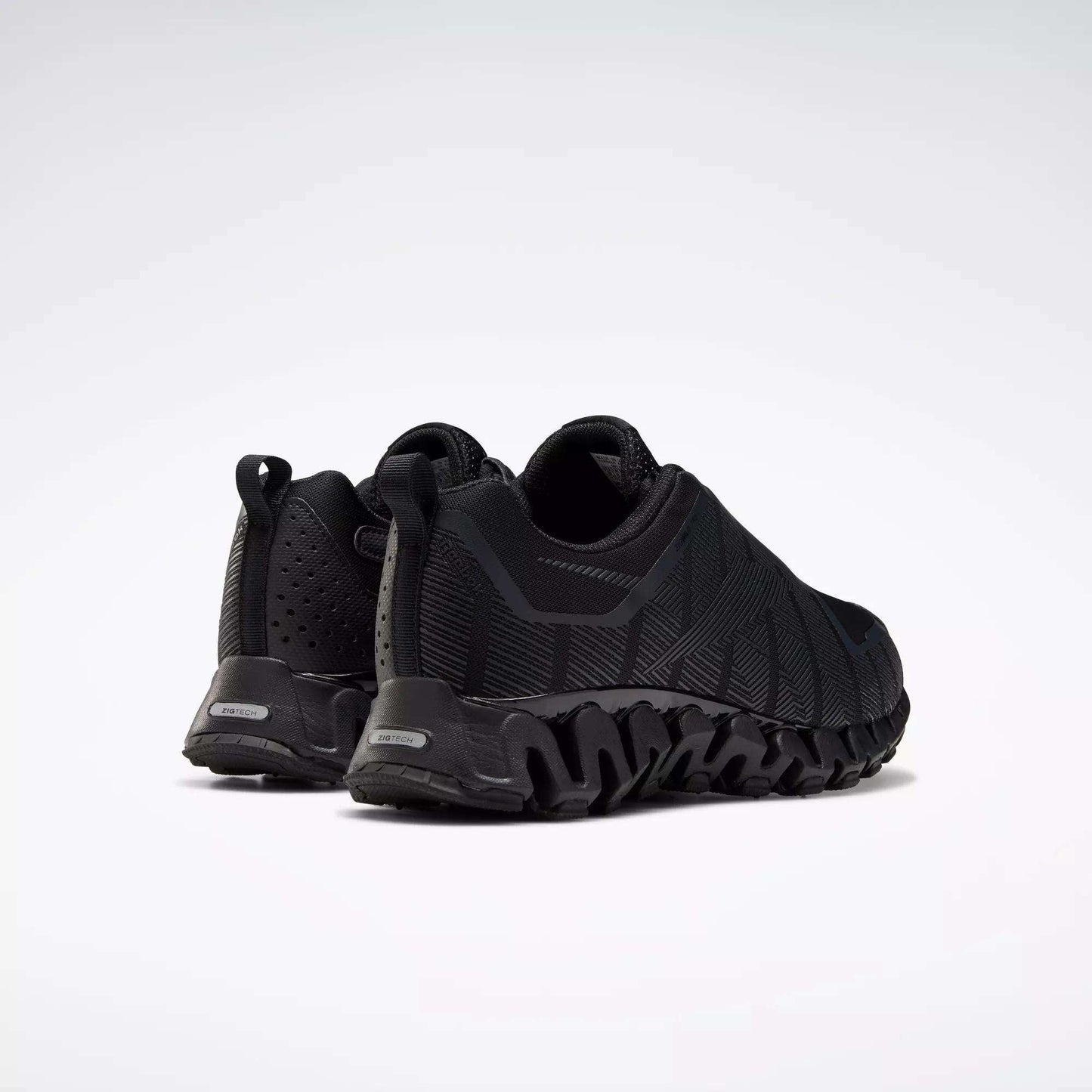 The Reebok Men's ZigWild Trail 6 Shoes are black running shoes with textured soles, shown from the back and side on a white background. They feature a rugged, trail-inspired design with geometric patterns and enhanced cushioning for comfort.