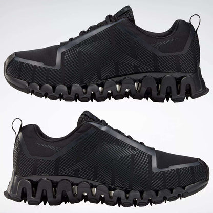 The Reebok Men's ZigWild Trail 6 Shoes in black feature geometric patterns and unique zigzag soles with enhanced cushioning, displayed in profile view against a plain light background.