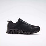 The Reebok Men's ZigWild Trail 6 Shoes, shown in profile against a white background, feature a black design with a textured geometric pattern and a thick wavy sole for enhanced cushioning.