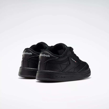 A pair of Reebok Kids' Club C Shoes for toddlers in black, shown from the back and side with visible logo, soft leather, and stitching details on a plain white background.