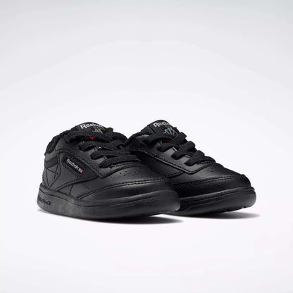 A pair of Reebok Kids' Club C Shoes for babies and toddlers, featuring a low-cut black leather design with laces and brand logos on the side and tongue, displayed on a plain white background.