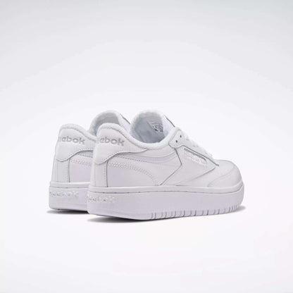 A pair of Reebok Women's Club C Double Shoes in white are displayed on a plain white background, with one shoe slightly ahead of the other, both facing backward.