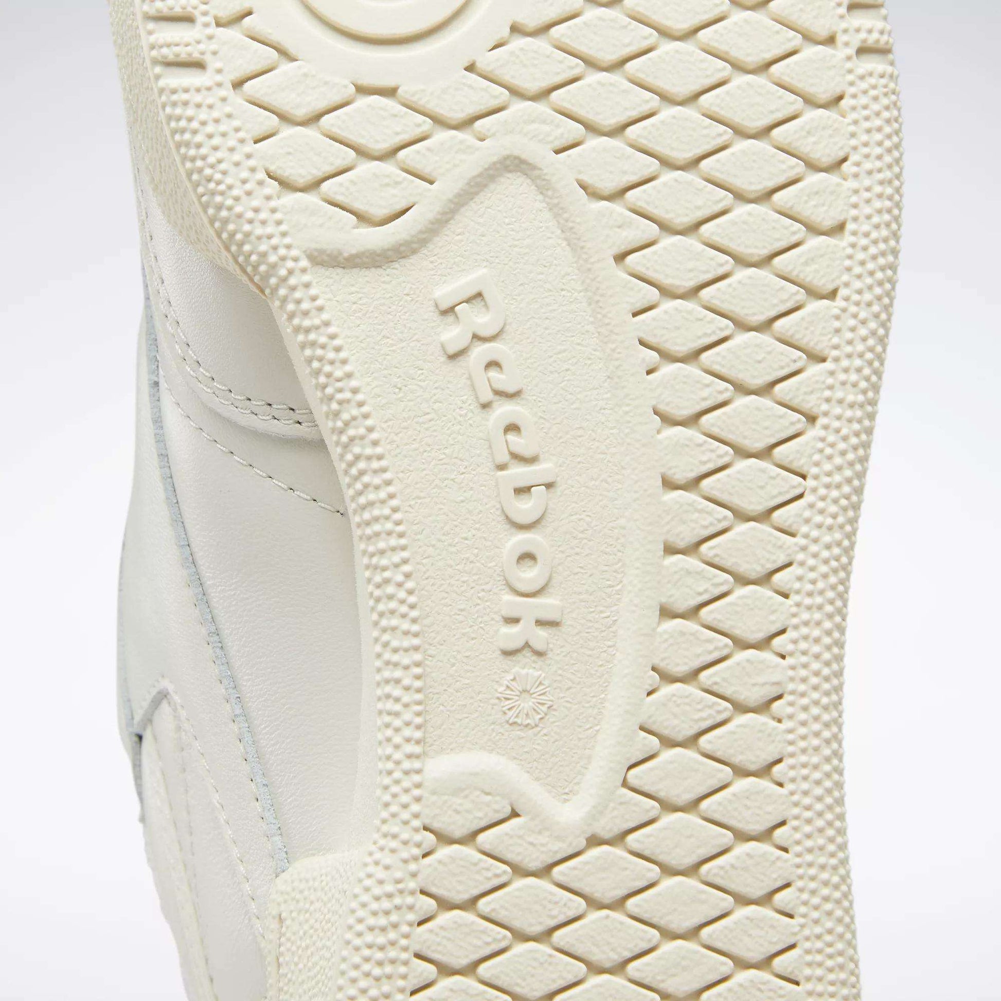 Close-up of the off-white sole of the Reebok Club C 85 Vintage Shoes, featuring the iconic logo in raised letters and a diamond-textured pattern for grip. Designed for comfort with lightweight cushioning.