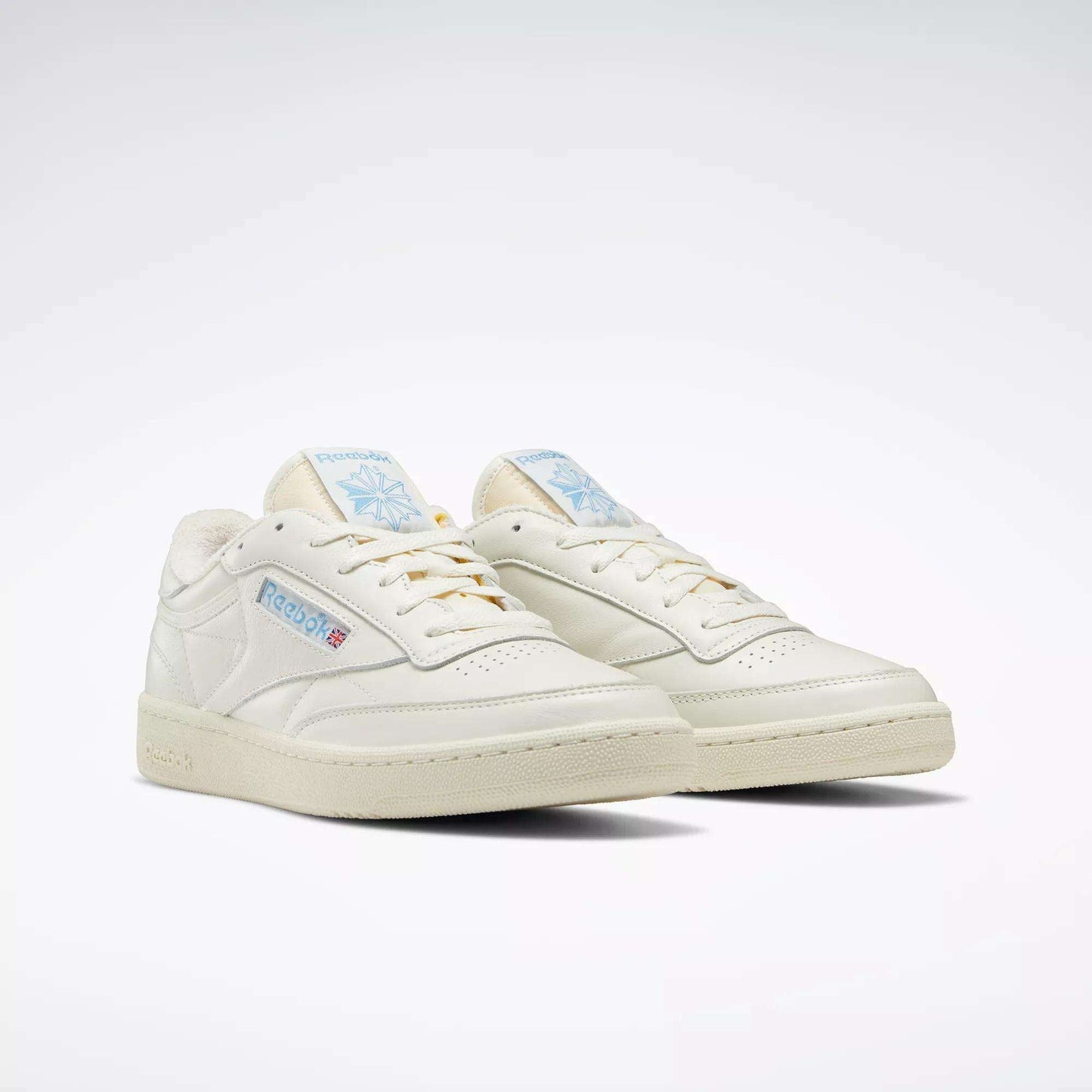 A pair of Reebok Club C 85 Vintage Shoes in off-white with blue and red logo accents, featuring a classic low-top leather upper and cream soles, displayed on a plain white background.