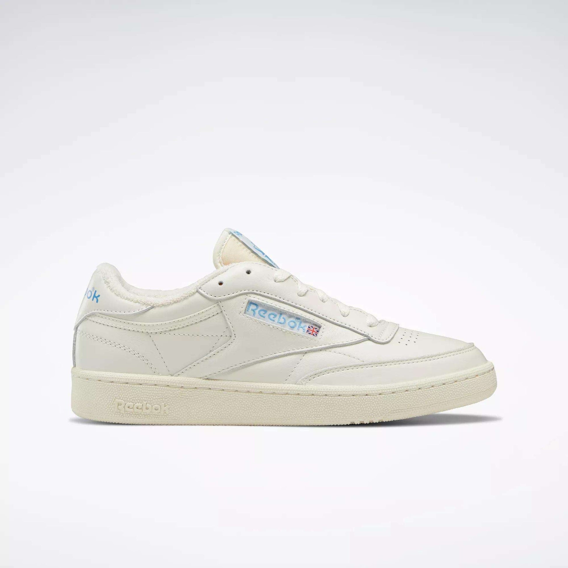 The Reebok Club C 85 Vintage Shoes feature a cream leather upper, blue accents, and a side Reebok logo, shown on a plain white background.