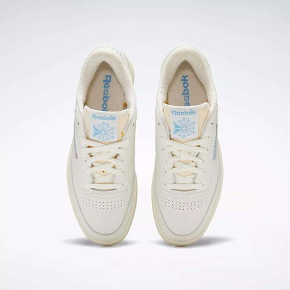 A pair of Club C 85 Vintage Shoes by Reebok, seen from above, with an off-white leather upper, light blue Reebok branding on the tongue and side, cream laces, and a soft textured inner lining.
