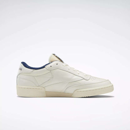 The Reebok Club C 85 Vintage Shoes showcase a cream leather upper, low-top silhouette, navy inner lining, and fine stitching, displayed in a side profile against a plain light background.