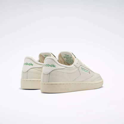 A pair of Women's Club C 85 Vintage Shoes by Reebok in off-white leather with green branding and text, shown angled on a light background to display the back and side views.