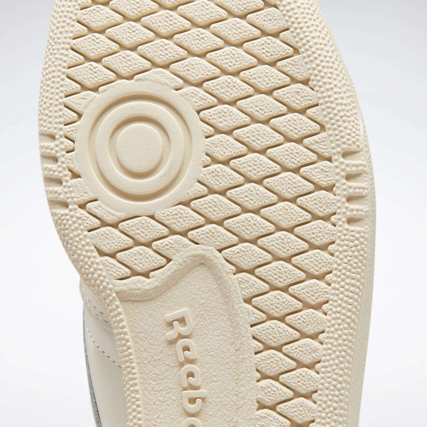 Close-up of the textured beige sole of a Reebok Women's Club C 85 Vintage Shoe, showing a circular pattern and the embossed Reebok logo.