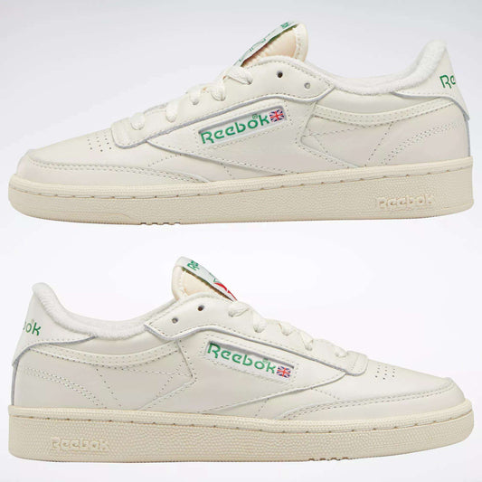 Two off-white Reebok Women's Club C 85 Vintage Shoes with green logos and Union Jack flags are shown side view on a white background. These leather sneakers feature cream-colored soles and subtle stitching details.