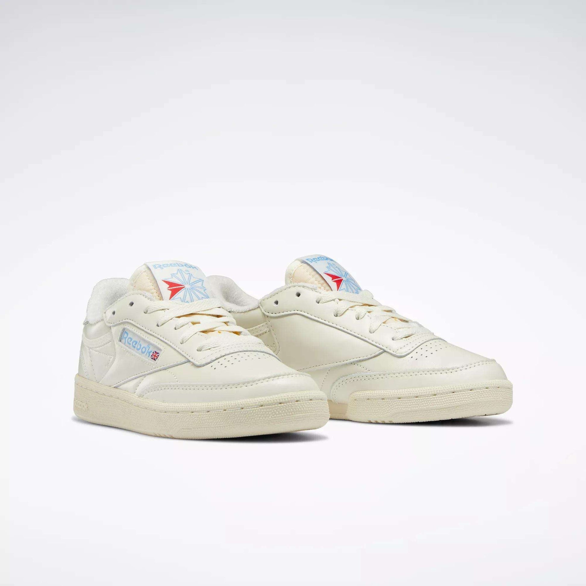 The Reebok Women's Club C 85 Vintage Shoes are off-white with blue and red logo details on the sides and tongue, shown against a plain white background.