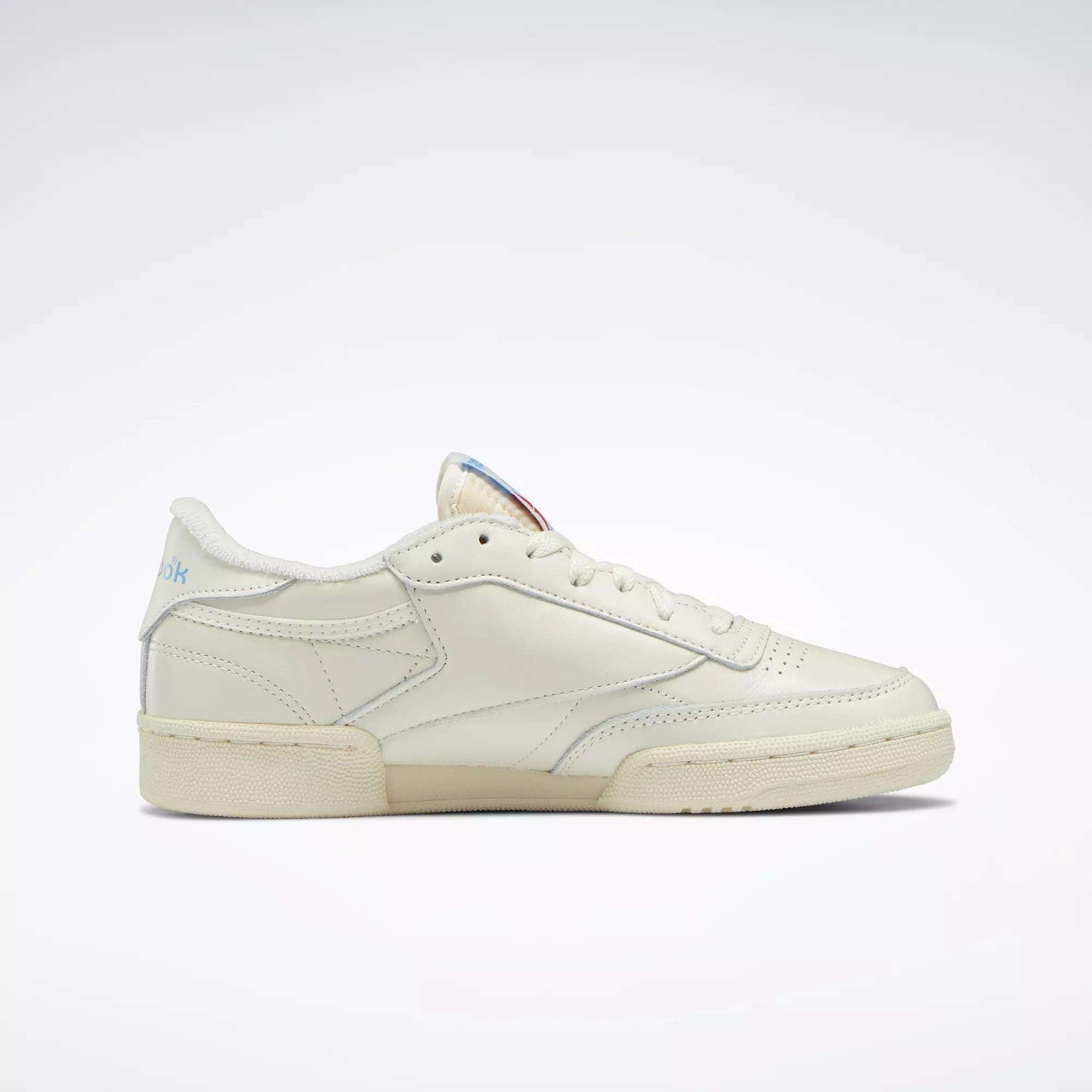 The Reebok Women's Club C 85 Vintage Shoes, shown in side profile against a white background, feature a cream color, low-top design, visible stitching, and classic rubber sole inspired by tennis styles.