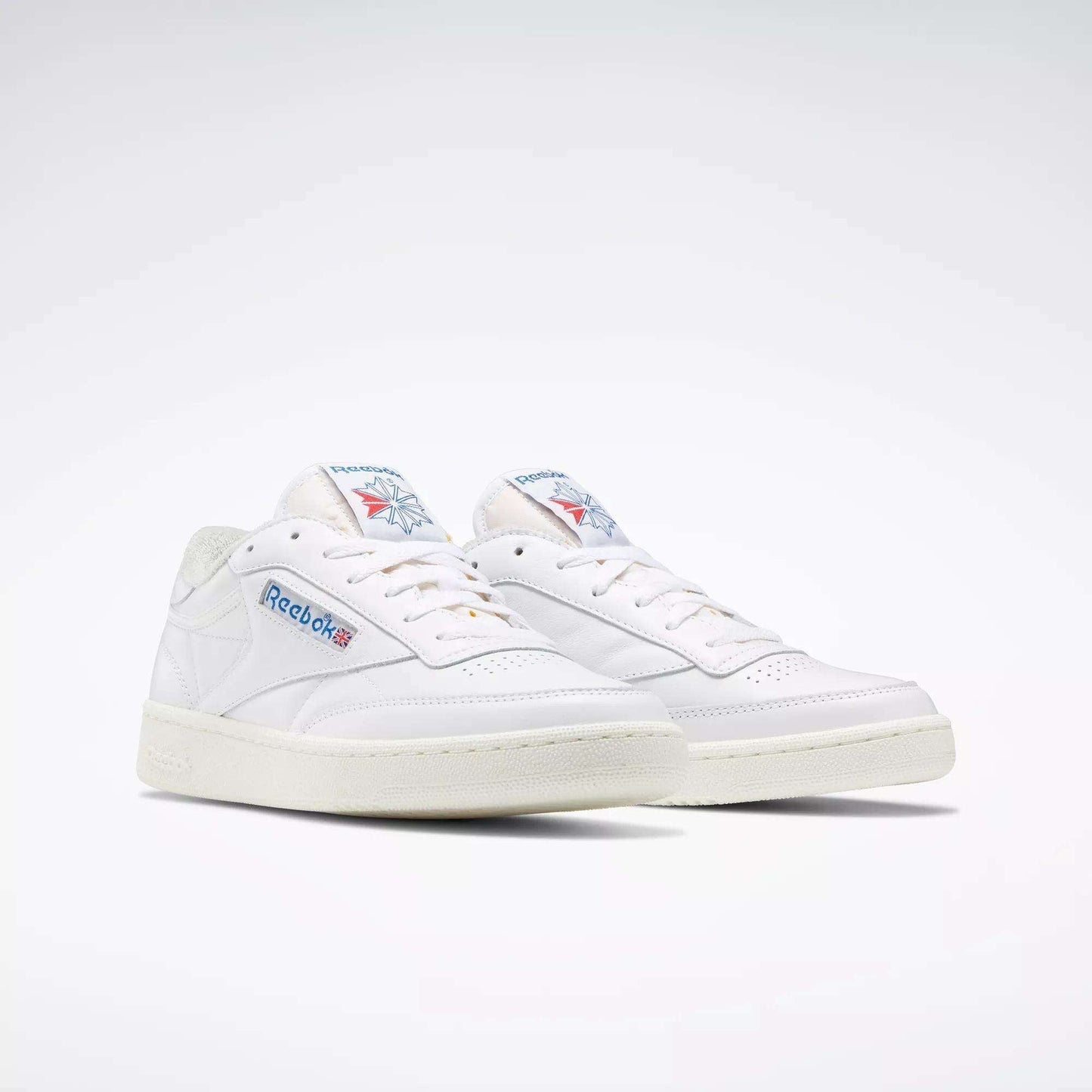 A pair of Reebok Club C 85 Vintage Shoes with a white leather upper, blue and red branding, off-white soles and laces, displayed against a plain light background.