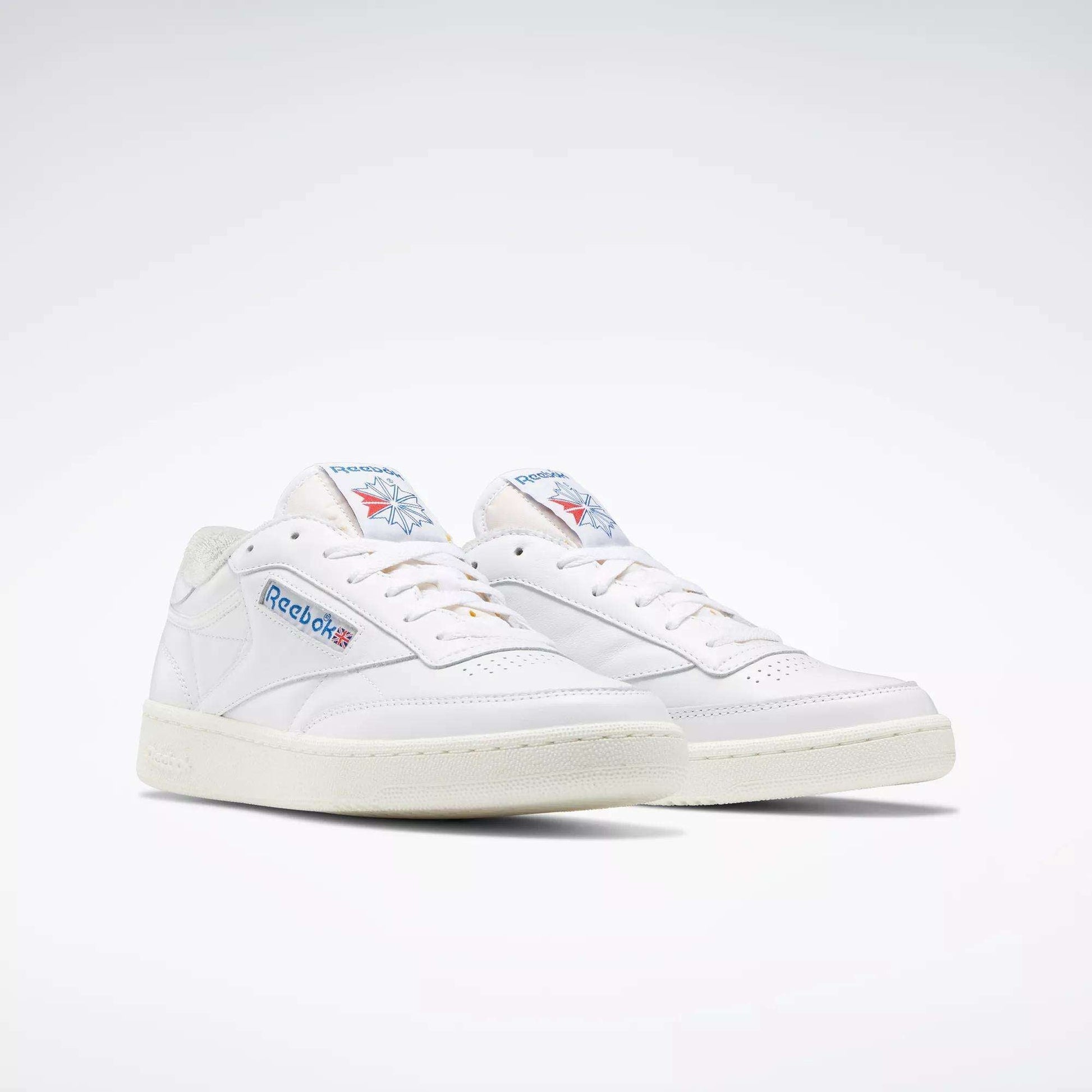 A pair of Reebok Club C 85 Vintage Shoes with a white leather upper, blue and red branding, off-white soles and laces, displayed against a plain light background.