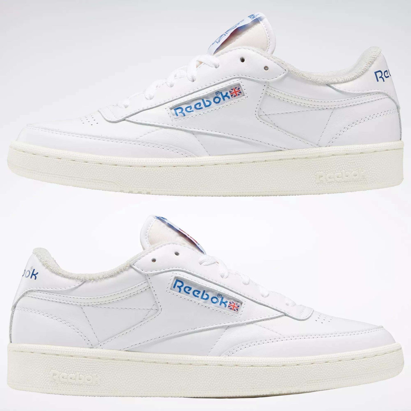 Two white Reebok Club C 85 Vintage Shoes displayed side view on a white background. The leather upper features blue Reebok branding with the British flag, off-white soles, and minimal stitching for lightweight comfort and style.