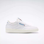 The Reebok Club C 85 Vintage Shoes feature a white leather upper with blue and red branding on the side and tongue, a low-top design, and a textured off-white sole with lightweight cushioning. Displayed on a plain white background.