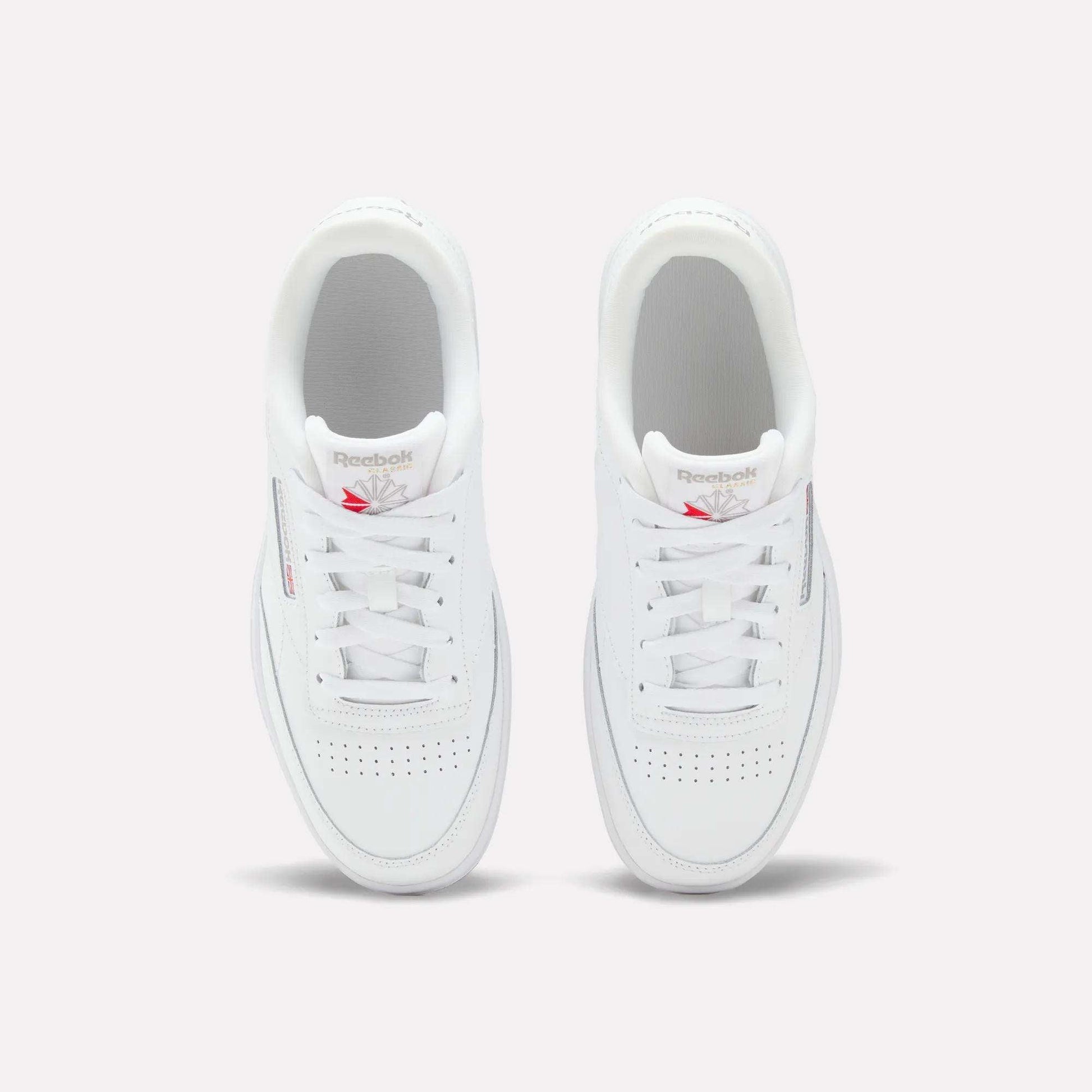 The Reebok Club C Double Shoes for big kids feature a leather upper, white laces, and a red Reebok logo on the tongue—seen from above on a light background—making them the perfect classic girls' shoes.