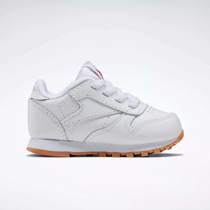 The Reebok Kids' Classic Leather Shoes for babies and toddlers feature white laces and a light brown rubber sole, shown against a plain white background.