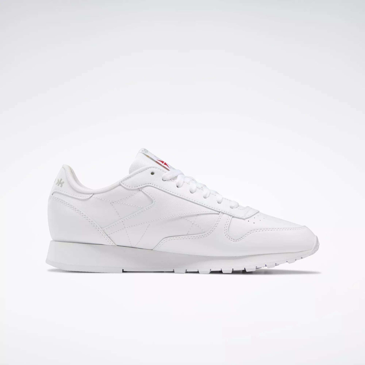 The Reebok Classic Leather Shoes are white low-top sneakers inspired by retro designs, with white laces and subtle branding, shown against a simple light background.